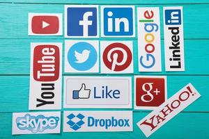 kiev, ukraine - 10 mars 2017. collection de logos de médias sociaux populaires imprimés sur papier you tube, facebook, twitter, google plus, yahoo, linkedin, skype, dropbox et autres sur fond de bois bleu. photo