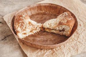 morceau de tarte aux pommes maison dans une assiette en papier sur un fond en bois. vue de dessus. copie, espace vide pour le texte photo