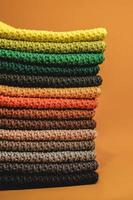 pile de tissu tricoté à partir de fils multicolores sur fond orange. copie, espace vide pour le texte photo