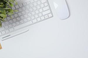 vue de dessus bureau de travail avec clavier souris et ordinateur portable sur fond de tableau blanc photo