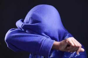 homme triste au visage de couverture de capot avec des mains isolées en noir. photo