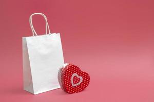 maquette de sac blanc artisanal et boîte-cadeau en forme de coeur isolé sur fond blanc. idée de commerce, vente. fermer photo