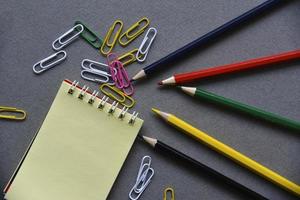 bloc-notes crayons et trombones sur le bureau photo