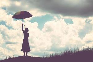 silhouette de femme tenant un parapluie journée ensoleillée photo