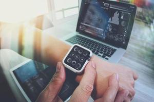 concepteur de site Web travaillant avec une montre intelligente et une tablette numérique et un diagramme de conception numérique sur un bureau en bois comme concept photo