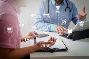 médecin utilisant un téléphone portable et consultant un homme d'affaires patient ayant un examen comme concept de professionnalisme hospitalier photo