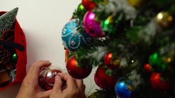 concept de saison de salutation.réglage à la main d'ornements sur un arbre de noël avec lumière décorative photo