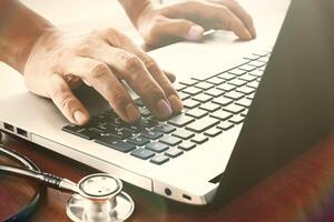 Main de médecin travaillant avec un ordinateur portable dans le bureau de l'espace de travail médical comme concept photo