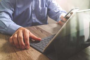 homme d'affaires prospère utilisant un téléphone intelligent, une tablette numérique, un clavier intelligent, sur un bureau en bois, un effet de filtre photo