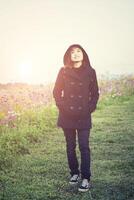 jeune femme heureuse debout dans un jardin fleuri photo