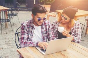 jeune couple hipster buvant parler s'amusant rire souriant heureux en plein air au style café europe. photo