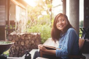 jeune femme lisant un livre assis sur la chaise. vacances reposantes profiter de la lecture. photo