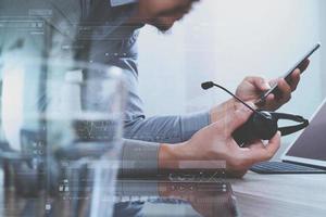 homme utilisant un casque voip avec un ordinateur tablette numérique amarrant un clavier intelligent, communication conceptuelle, support informatique, centre d'appels, icônes virtuelles graphiques à écran numérique, graphique, diagramme photo