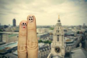 l'heureux couple de doigts amoureux de smiley peint sur l'arrière-plan flou de la ville de londres photo