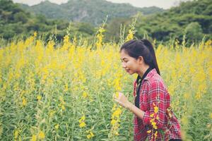 belle jeune femme debout dans le plaisir du champ de fleurs. photo
