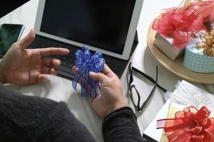 cadeau donnant la main créative choisissant et main avec cadeau. livraison de cadeaux, surprise, ordinateur tablette amarrage clavier intelligent téléphone intelligent sur un bureau mable, effet de film vintage photo