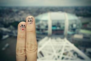 l'heureux couple de doigts amoureux de smiley peint sur l'arrière-plan flou de la ville de londres photo