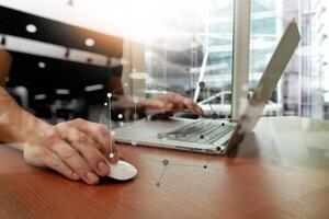 gros plan sur une main d'homme d'affaires travaillant sur un ordinateur portable sur un bureau en bois photo