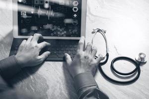 concept de technologie médicale. main de médecin travaillant avec un ordinateur à écran de station d'accueil pour tablette numérique moderne avec interface de dossier médical, photo à effet de lumière solaire, noir blanc