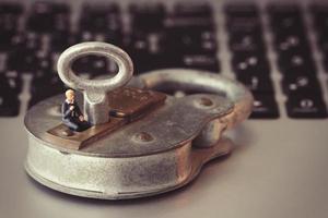 concept de sécurité internet-homme d'affaires miniature debout sur l'ancienne clé et cadenas sur le clavier de l'ordinateur portable photo