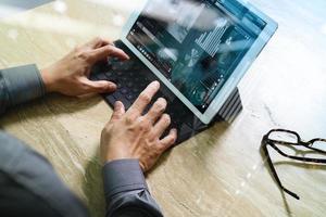 concept de travail à la main d'homme d'affaires. investisseur photo travaillant avec un nouveau projet de démarrage. tablette numérique clavier dock écran conception d'ordinateur téléphone intelligent à l'aide. lunettes sur un bureau en marbre. effet de lumière solaire