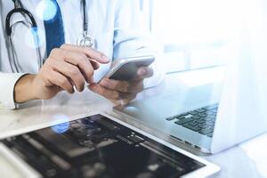 concept de technologie médicale. main de médecin travaillant avec une tablette numérique moderne et un ordinateur portable avec interface de dossier médical, photo d'effet de lumière solaire