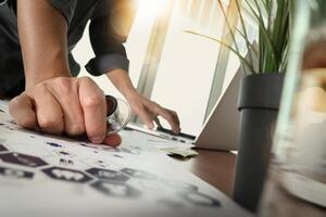 médecin travaillant avec un ordinateur portable dans un bureau d'espace de travail médical et un diagramme de média de réseau médical avec un verre d'eau et une plante verte au premier plan en tant que concept photo