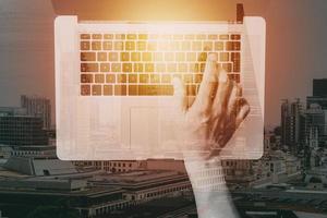 vue de dessus d'un homme d'affaires tapant du clavier avec un ordinateur portable sur un bureau en bois dans un bureau moderne avec un schéma d'icône de réalité virtuelle avec exposition au bâtiment photo