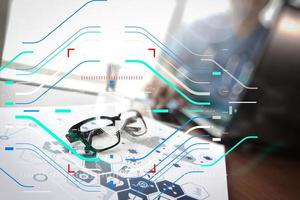 médecin travaillant avec un ordinateur portable et un verre oculaire dans le bureau de l'espace de travail médical et le diagramme des médias du réseau médical en tant que concept photo