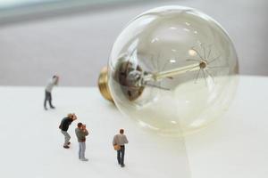 concept d'idée créative - photographe miniature avec ampoule vintage sur carnet de papier ouvert photo