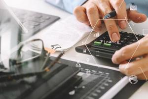 main d'homme d'affaires travaillant avec les finances sur le coût et la calculatrice et latop avec téléphone portable sur le bureau blanc dans un bureau moderne photo