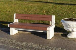 Banc élégant dans un parc d'été en béton et bois. photo