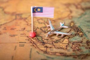 le drapeau de la malaisie et l'avion sur la carte du monde. photo
