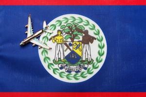 avion sur le concept de voyage du drapeau du belize. avion jouet sur un drapeau. photo