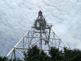 vue de haut en bas de la tour de télécommunication aperçu botton sur la construction avec un ciel de bas en haut avec des nuages blancs photo