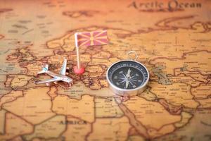 drapeau de macédoine, boussole et avion sur la carte du monde. photo