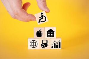 icônes pour personnes handicapées sur des cubes en bois, fond jaune. photo