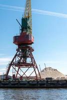 de nombreuses grues de chargement de grande taille se dressent sur les rives de la rivière venta. ventspils, lettonie, mer baltique. photo