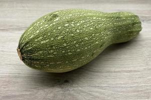 courgettes crues fraîches isolées sur fond de bois photo