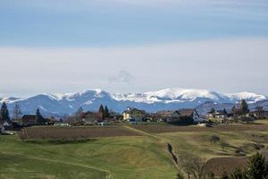 panorama d'un village en autriche sur fond de montagnes enneigées en hiver. photo