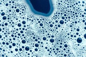 bulles de savon sur fond d'eau bleue comme texture. vue de dessus. copie, espace vide pour le texte