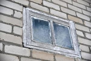 une petite fenêtre blanche dans un mur de briques photo