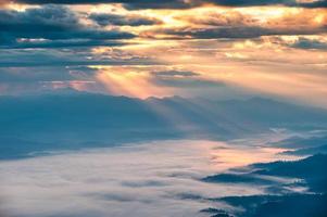 Rayon de soleil brillant à travers nuageux sur la montagne doi luang chiang dao et brumeux le matin photo