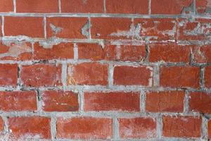 une vieille imitation en lambeaux d'un mur de briques. brique rouge, coulis blanc. photo