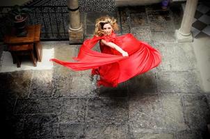 belle femme blonde, vêtue d'une robe rouge, sautant photo