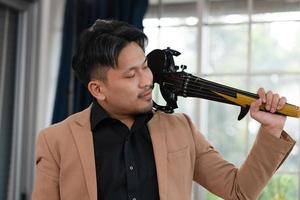 portrait de violoniste asiatique tenant un violon électrique photo