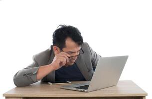 homme d'affaires stressé travaille avec un ordinateur portable assis à table isolé sur fond blanc. photo