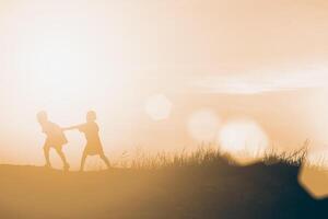 silhouette enfants jouant happy time au coucher du soleil photo