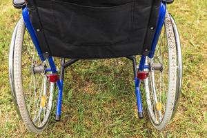 fauteuil roulant vide debout dans le parc de l'hôpital en attente de services aux patients. fauteuil roulant pour personne handicapée garé à l'extérieur. accessible pour personne handicapée. concept médical de soins de santé. photo