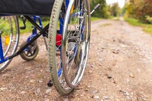 fauteuil roulant vide debout sur la route en attente de services aux patients. fauteuil roulant pour personne handicapée garé à l'extérieur. accessible pour personne handicapée. concept médical de soins de santé. photo